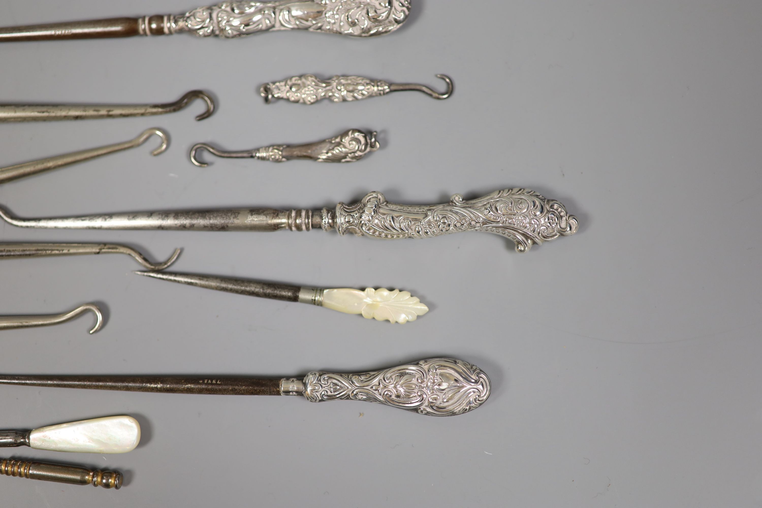 A collection of assorted silver handle button hooks and a nail implement.